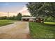 Charming brick home with a metal roof, carport, and a spacious driveway at sunset at 133 Jo Monni Loop, Statesville, NC 28625