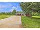Charming brick home features a covered carport, a well-manicured lawn, and mature trees at 133 Jo Monni Loop, Statesville, NC 28625