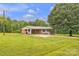 Ranch style brick home with a metal roof surrounded by a lush lawn at 133 Jo Monni Loop, Statesville, NC 28625