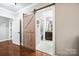 Hallway with barn door that leads to the serene bathroom featuring elegant fixtures and finishes at 13407 Hazelbrook Ln, Cornelius, NC 28031