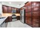 Gourmet kitchen features stainless steel appliances, rich wooden cabinetry, and ample storage for a chef-inspired cooking experience at 13407 Hazelbrook Ln, Cornelius, NC 28031