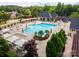 Aerial view of a community pool with palm trees, lounge chairs, and tables with umbrellas at 13407 Hazelbrook Ln, Cornelius, NC 28031