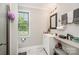 Bright bathroom with a large mirror, shelving, and a window with natural light at 1406 W Walnut Ave, Gastonia, NC 28052