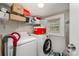 Functional laundry room with washer, dryer, shelving, and a window for natural light at 1406 W Walnut Ave, Gastonia, NC 28052