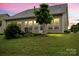 This backyard features a well manicured lawn and shrubbery at dusk at 1409 Tupelo Rd, Clover, SC 29710