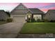 Charming single-Gathering home with a two-car garage, complemented by a lush lawn and manicured landscaping at 1409 Tupelo Rd, Clover, SC 29710