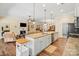Kitchen with island and stainless steel appliances opens to living and dining rooms with hardwood floors at 1409 Tupelo Rd, Clover, SC 29710