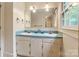 Bright bathroom with double sinks, large mirror, and vintage-style fixtures and wallpaper at 1513 Shelby Hwy, Cherryville, NC 28021