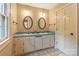 Bathroom with double sinks, vintage tile floor, and blue countertops underneath oval mirrors at 1513 Shelby Hwy, Cherryville, NC 28021