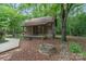 Rustic log cabin with a covered porch and stone firepit in a wooded setting at 1513 Shelby Hwy, Cherryville, NC 28021