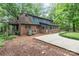 Back exterior of the home featuring brick and blue siding, surrounded by mature trees at 1513 Shelby Hwy, Cherryville, NC 28021