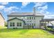 Expansive backyard with lush lawn, a stone outdoor kitchen, and a covered pergola seating area at 15637 Guthrie Dr, Huntersville, NC 28078