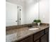 Bathroom vanity featuring a granite countertop, dark wood cabinets, and a large mirror at 15637 Guthrie Dr, Huntersville, NC 28078