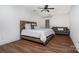 Comfortable bedroom featuring a tufted headboard, a ceiling fan, wood flooring, and a cozy sofa at 15637 Guthrie Dr, Huntersville, NC 28078