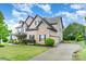 A beautiful home with stone accents, well-manicured lawn and long driveway at 15637 Guthrie Dr, Huntersville, NC 28078