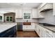 Kitchen featuring granite countertops, white cabinetry, mosaic backsplash, and a copper sink at 15637 Guthrie Dr, Huntersville, NC 28078