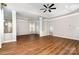Bright living room featuring tray ceilings, hardwood floors, ceiling fan, and white support columns at 15637 Guthrie Dr, Huntersville, NC 28078
