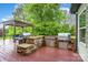 Well-equipped outdoor kitchen featuring stone counters and stainless steel grills on a stained wood deck at 15637 Guthrie Dr, Huntersville, NC 28078