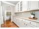 Well-lit pantry featuring granite countertops, white cabinetry, and hardwood floors at 15637 Guthrie Dr, Huntersville, NC 28078