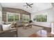 Cozy sunroom with wood-paneled walls, large windows, and comfortable seating area at 15637 Guthrie Dr, Huntersville, NC 28078