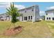 Backyard view of a gray two-story townhouse with patio, lawn and young tree at 1712 Braemar Village Dr, Monroe, NC 28110