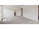 Bedroom with neutral walls, plush carpet, and doorways leading to a closet and bathroom at 1712 Braemar Village Dr, Monroe, NC 28110