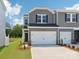 Two-story townhome with gray siding, black shutters, two car garage, and well-manicured landscaping at 1712 Braemar Village Dr, Monroe, NC 28110