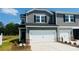 Charming townhome featuring a two-car garage, gray siding, black shutters and professionally landscaped front yard at 1712 Braemar Village Dr, Monroe, NC 28110