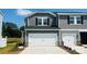 Charming townhome featuring a two-car garage, gray siding, black shutters and professionally landscaped front yard at 1712 Braemar Village Dr, Monroe, NC 28110