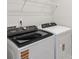 Modern laundry room with side-by-side washer and dryer units and wire shelving at 1712 Braemar Village Dr, Monroe, NC 28110