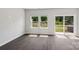 Living room with dark wood floors, natural light from the windows and glass door with a view of the backyard at 1712 Braemar Village Dr, Monroe, NC 28110