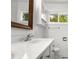 Close up of a bathroom with double sinks, white cabinets, and a framed mirror reflecting natural light at 1725 Fallston Rd, Shelby, NC 28150
