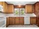 The kitchen has wooden cabinets, white countertops and appliances, and a double sink at 1725 Fallston Rd, Shelby, NC 28150