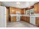 Functional kitchen featuring wood cabinets, white appliances, and a light tile floor at 1725 Fallston Rd, Shelby, NC 28150