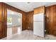 This simple kitchen has wood paneling and cabinets, a white refrigerator, and tile flooring at 1725 Fallston Rd, Shelby, NC 28150