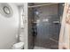 Bathroom showcasing a gray tiled shower, a modern commode, and a decorative mirror at 1759 Nw Pipers Ridge Cir, Conover, NC 28613