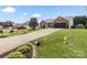 Well-manicured lawn and long driveway leading to a brick home with attached garage at 1759 Nw Pipers Ridge Cir, Conover, NC 28613