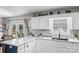 Spacious kitchen area with white cabinets, a kitchen island, and sliding glass doors to the outside at 1759 Nw Pipers Ridge Cir, Conover, NC 28613