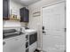 Bright laundry room featuring modern washer and dryer, overhead cabinets, and convenient access to the exterior door at 1759 Nw Pipers Ridge Cir, Conover, NC 28613