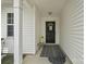 Covered front entry showcases a black door, flowers, and neutral accents at 181 Mott Rd, Mooresville, NC 28115