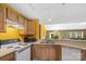 Well-lit kitchen with wood cabinets, white appliances, and view into living room at 181 Mott Rd, Mooresville, NC 28115