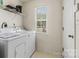 Functional laundry room with shelving, window, washer, and dryer hookups at 181 Mott Rd, Mooresville, NC 28115