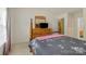 Well-lit bedroom with a four-poster bed, TV, dresser, and neutral walls at 181 Mott Rd, Mooresville, NC 28115