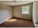 Bedroom with neutral walls, carpet, and a bright window, offering a serene space at 2020 Longleaf Dr, Charlotte, NC 28210