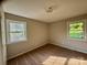 Comfortable bedroom with neutral walls, plush carpeting, and two windows providing natural light at 2020 Longleaf Dr, Charlotte, NC 28210