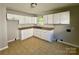 Functional kitchen with white cabinetry, neutral countertops, and convenient window placement at 2020 Longleaf Dr, Charlotte, NC 28210