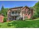 Spacious backyard showcasing a two-story brick home with a patio area and lush green lawn at 2129 Halford Pl, Charlotte, NC 28211