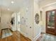 Inviting entryway with hardwood floors, coat rack with bench seating, and view to laundry room with modern appliances at 2129 Halford Pl, Charlotte, NC 28211