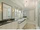 Luxurious bathroom featuring double sinks, soaking tub, chandelier, and a large mirror above the vanity at 2129 Halford Pl, Charlotte, NC 28211