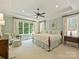 Bright main bedroom with tray ceiling, ceiling fan, neutral color palette, and large windows overlooking the yard at 2129 Halford Pl, Charlotte, NC 28211